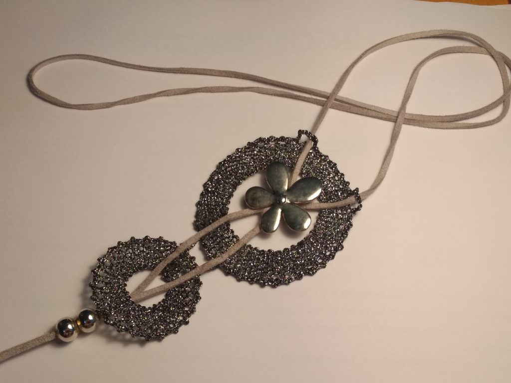 Collar con detalles realizados en encaje bolillos. Encaje actual y picada propia de la autora Mª José Rosel. Piezas de Zamac y cordón de antelina.